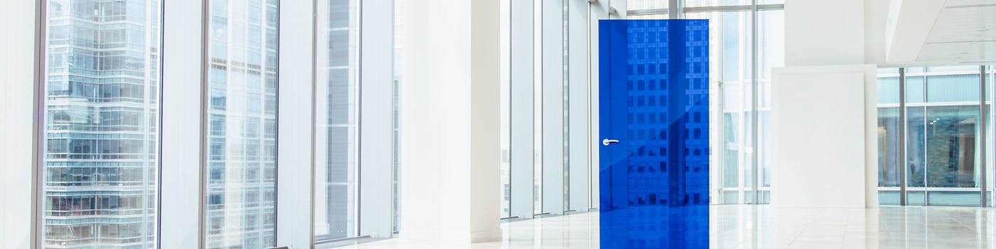 imagem de uma porta de vidro azul no meio de um escritório branco