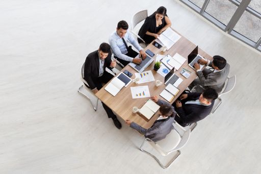 Diverse group of business people sitting around conference table