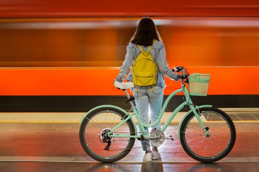 femme avec un vélo sur un quai de gare