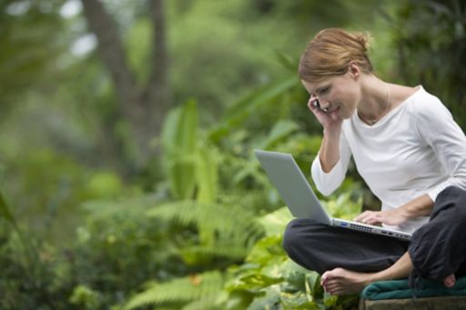 KPMG Global IFRS Institute image: woman in a forest using a laptop and a smartphone.
