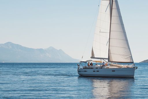 Sailboat on calm sea with mountains in background