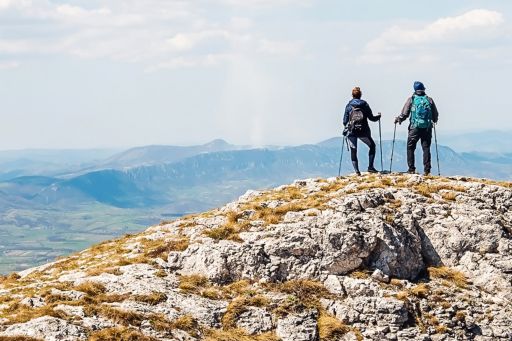 two people hiking on a cliff
