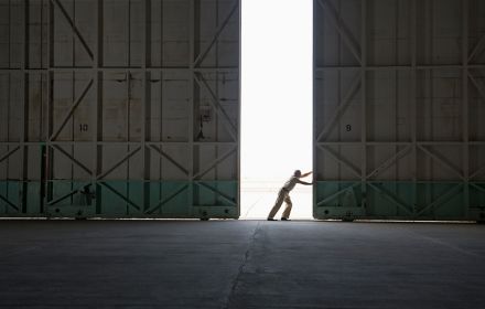 Worker opening large warehouse door
