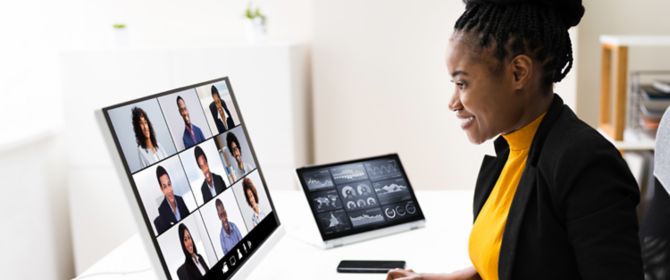 mulher sentada a frente do computador tendo uma reunição online