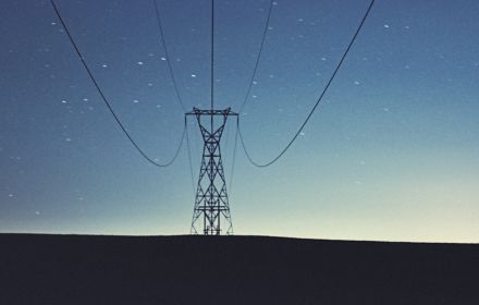 imagem de uma torre de energia eletrica com o céu anoitecendo