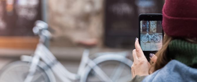 woman taking a picture of bicycle with mobile phone