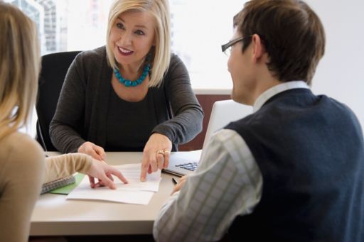 KPMG Accounting Advisory Services image: Three people discussing a document.