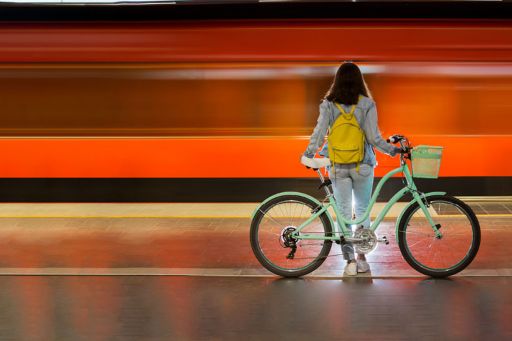Vrouw met fiets op treinplatform