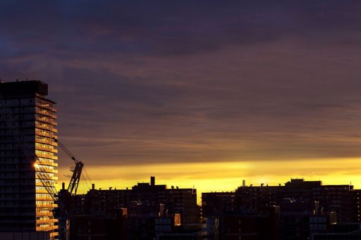 A high rise building being constructed at sunset