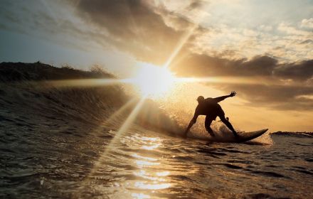 A man surfing at sunset