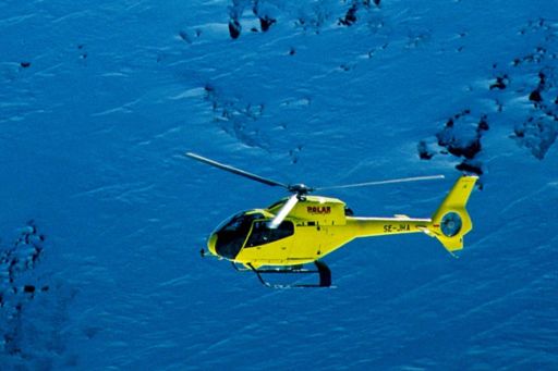 飞越山川的黄色直升机