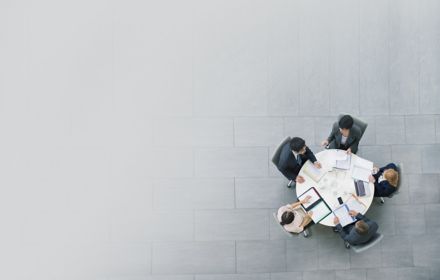 Aerial view of five business people doing meeting on round table