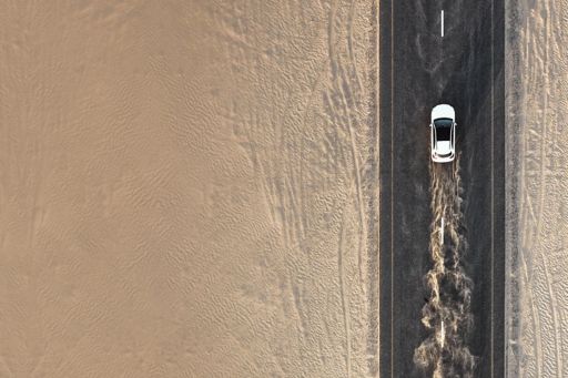 Aerial view of white car on a deserted highway running on high speed