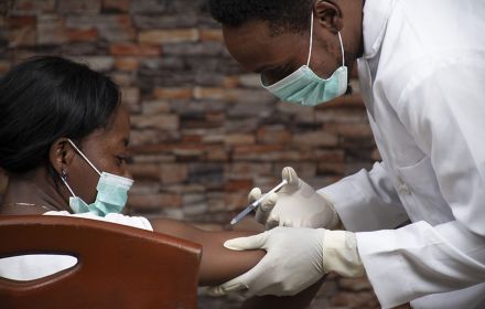 African doctor injecting a woman with a vaccine for COVID-19
