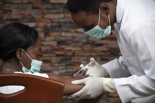 African doctor injecting a woman with a vaccine for COVID-19