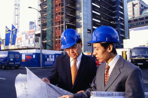 KPMG Impacts on the construction industry of the new revenue standard (IFRS 15) publication image: two architects discussing blueprints at a construction site