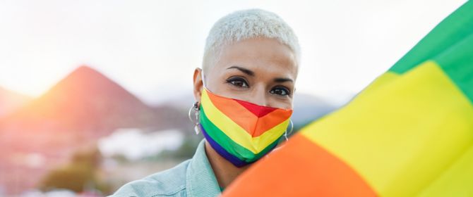 Beautiful latin lesbian woman with LGBT pride rainbow flag outdoor