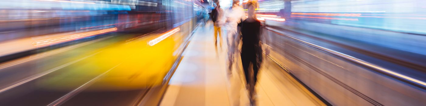 Blurred image of three people walking at a metro station