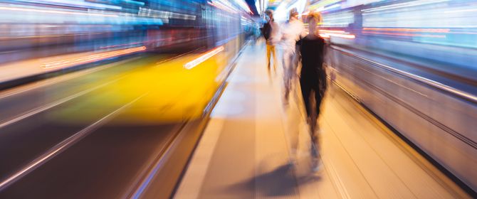 Blurred image of three people walking at a metro station