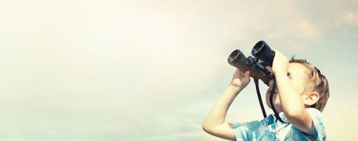 Boy looking up to the sky with binoculars