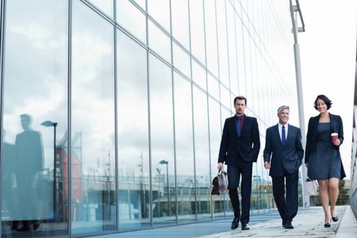 business-people-walking-by-glass-building