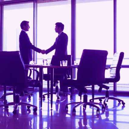 businessmen shaking hands in conference room
