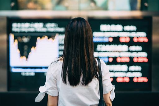 business woman looking at stock exchange market display screen