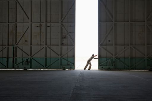 Worker opening warehouse doors