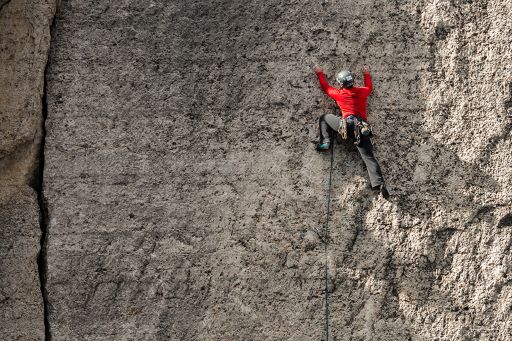 Rock climber wearing red outfit