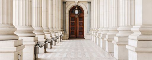 Marble columns and wooden door entrance to beautiful building