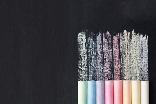 Colored chalks and black chalkboard