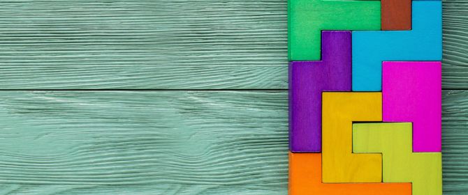 Colourful tetris blocks on a green wooden background