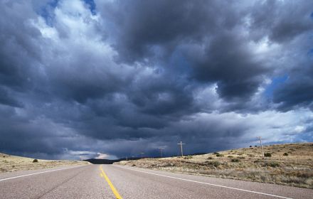 Dark clouds above a deserted road