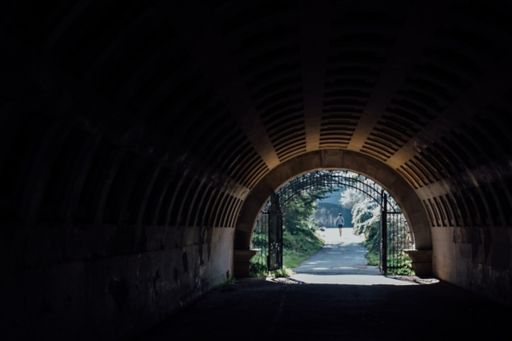 Dark tunnel leading to a park