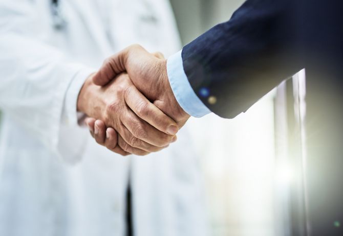 Doctor shaking hand with man