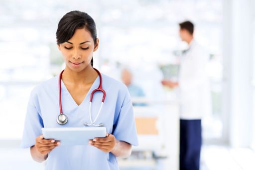 Doctor wearing stethoscope holding tablet with blur background