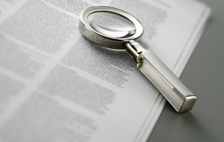 Document with magnifying glass on top