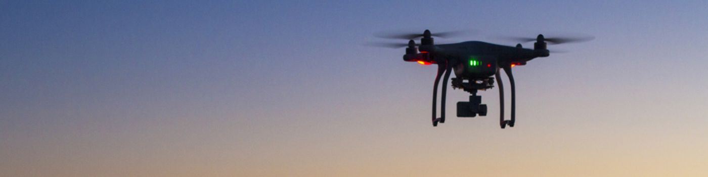 Drohne fliegt bei Sonnenuntergang
