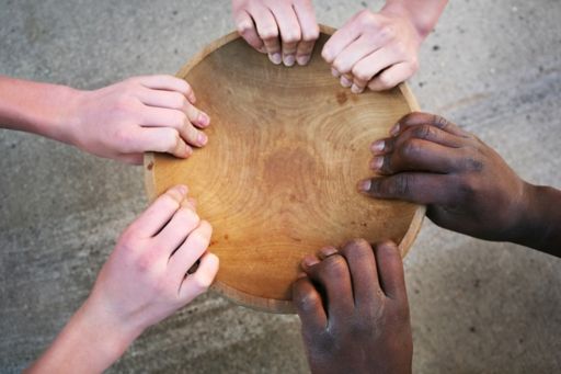 empty wooden bowl multi cultural hands