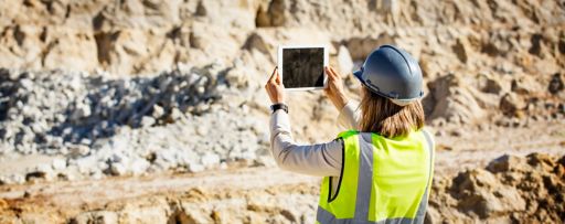 Female architect taking photograph on tablet with both hands