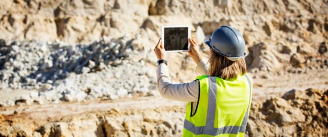 Female architect taking photograph on tablet with both hands
