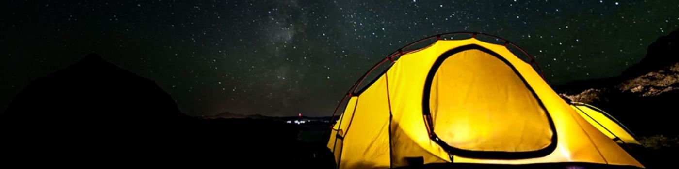 Yellow tent at night under a starry sky.