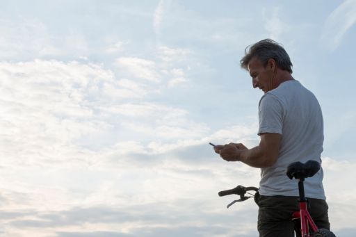 Un homme vérifie son téléphone sur son vélo