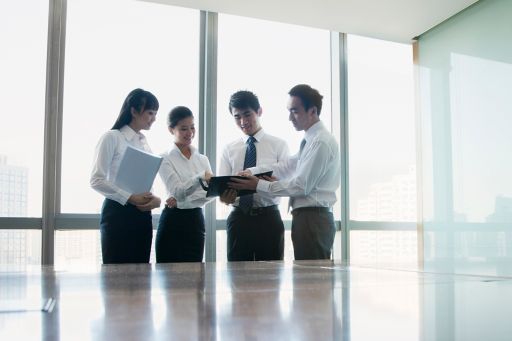 Four Young business people standing by conference table