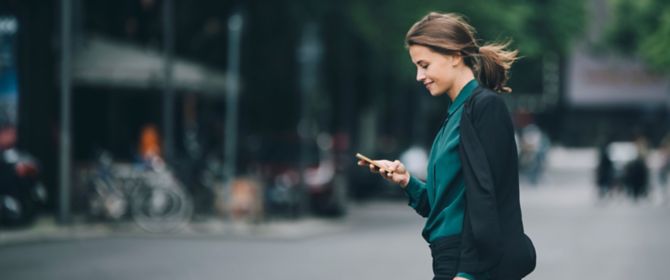 Frau läuft mit Smartphone in der Hand