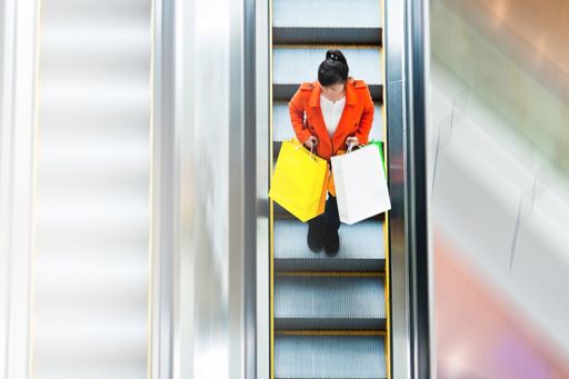 Woman with shopping bags on escalator