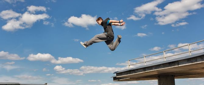 freeruner jumping between concrete in front of city