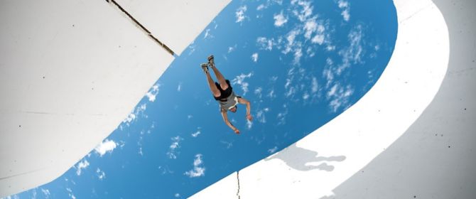 underneath view of freerunner jumping between concrete