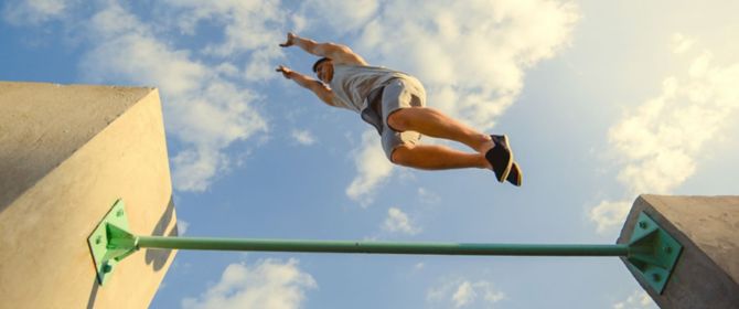 freerunner jumping over green rail 
