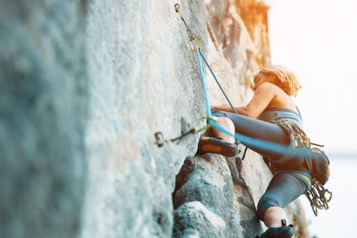 Girl climbing the mountains using ropes
